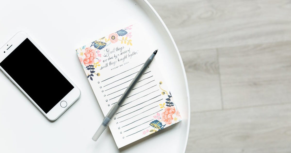 スマートフォンとノートパッドとペン