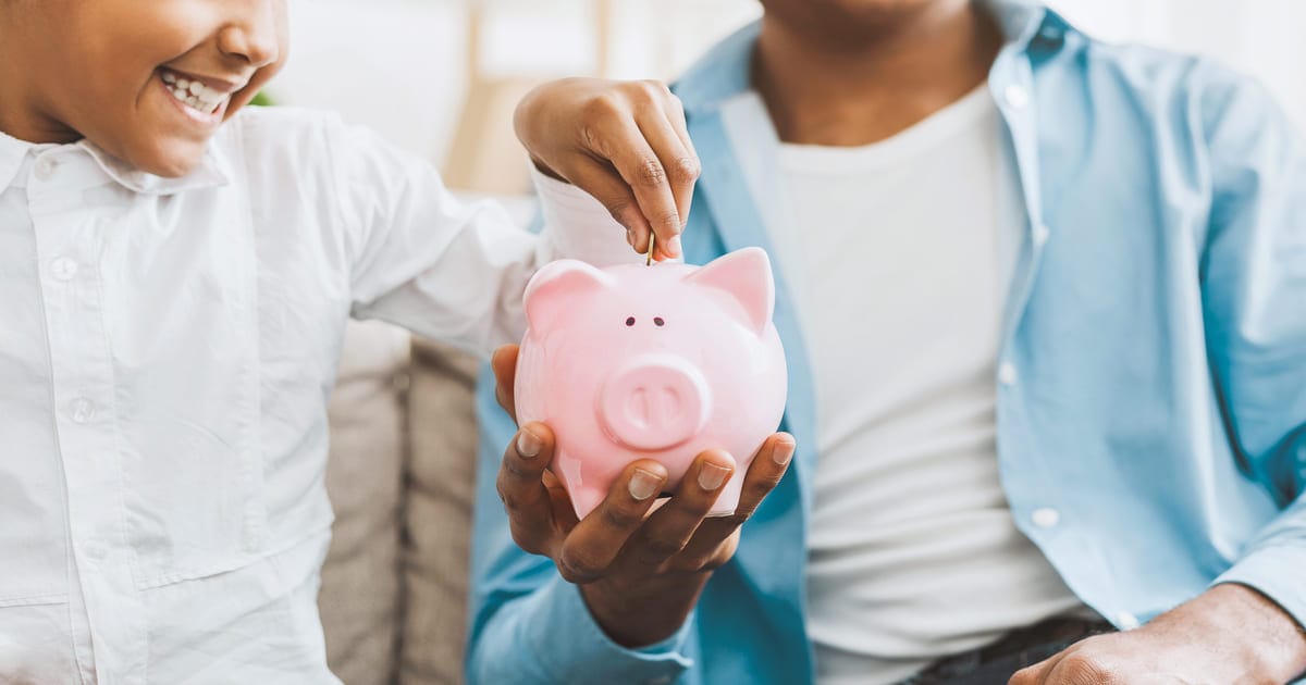 豚の貯金箱に硬貨を入れる人