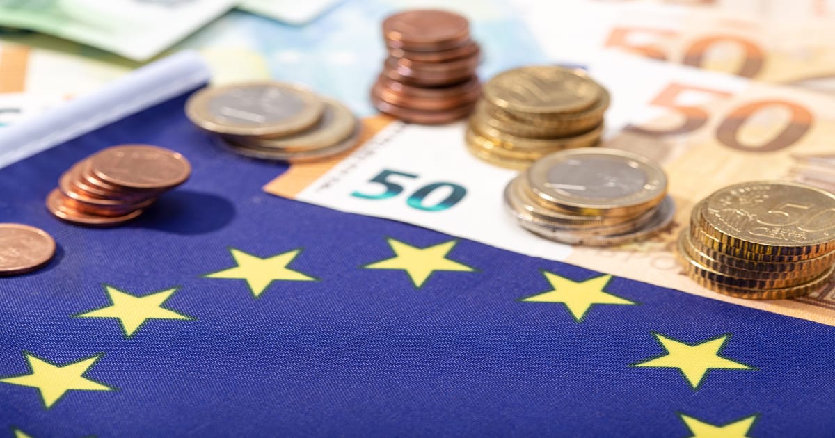 EUの旗の上にある硬貨と紙幣