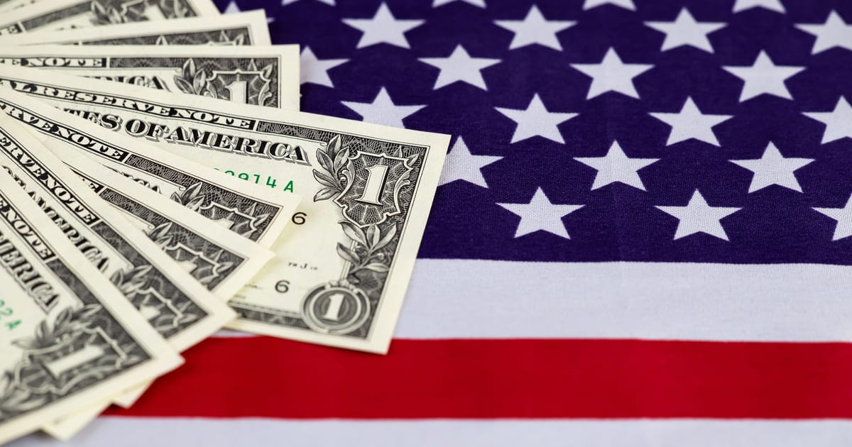 アメリカ国旗の上にあるドル紙幣