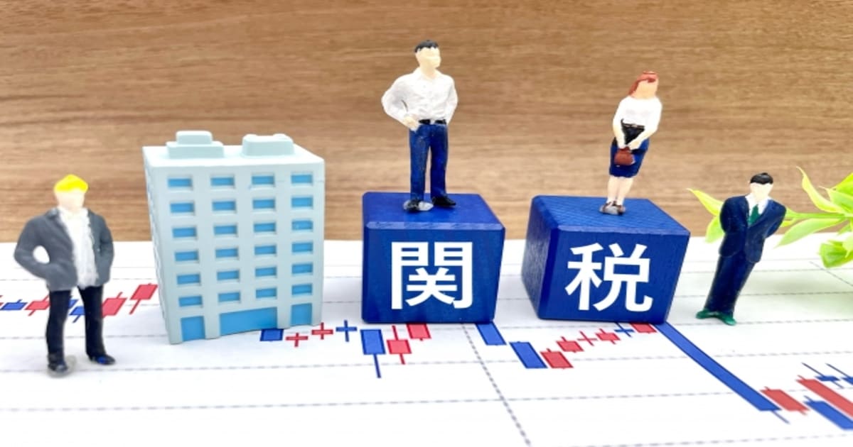 関税と書かれたブロックとビジネスマンのミニチュア