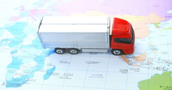 世界地図の上のミニチュアのトラック