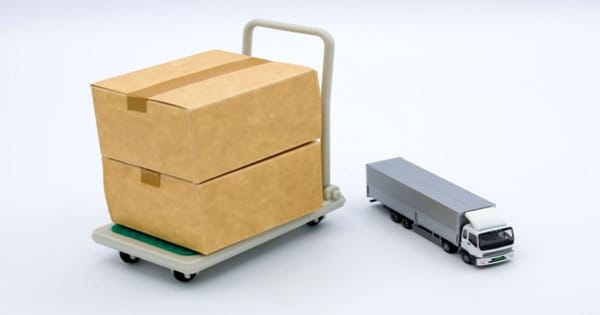 段ボール箱が積まれた台車とトラック